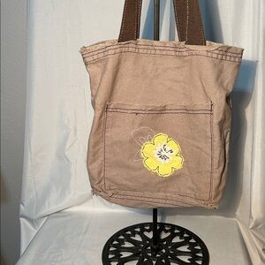 Thirty One tan canvas tote bag featuring an embroidered yellow flower design.